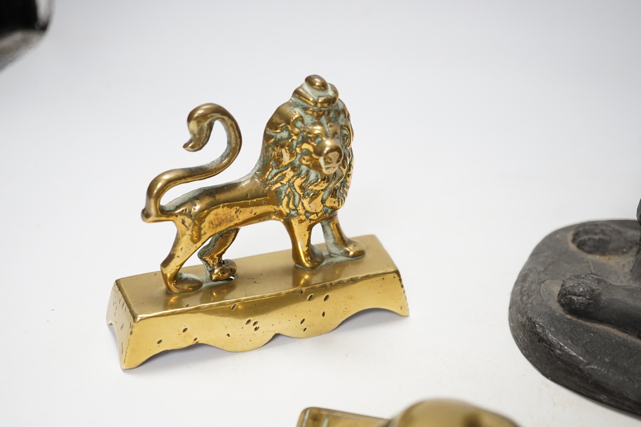 A 19th century brass recumbent lion, a similar cast iron lion and a smaller lion, largest 22cm wide